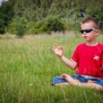 Child meditating in field