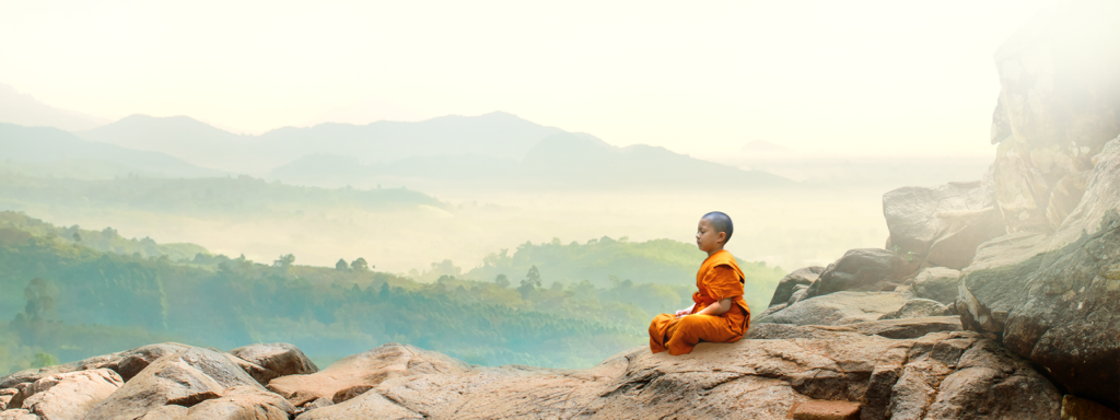 Monk meditating on mountains